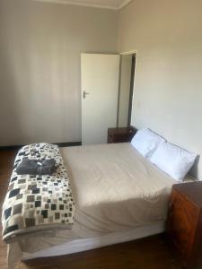 Un dormitorio con una cama grande y un armario. en The Cargo Club Guesthouse, en Ventersburg