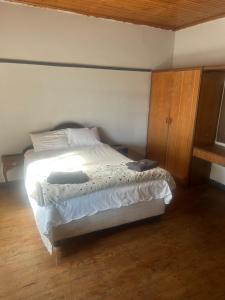 Un dormitorio con una cama y suelo de madera. en The Cargo Club Guesthouse, en Ventersburg 5 fotos más