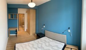 1 dormitorio con una pared azul y 1 cama en 2 suites dans un duplex, en Oloron-Sainte-Marie