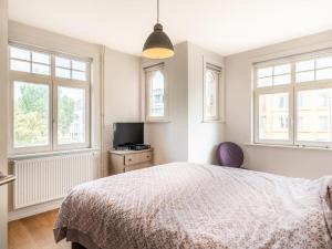 a bedroom with a bed and two windows at Au Coin in Galopen