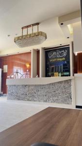 a bar in a restaurant with a counter top at نصف القمر للشقق المخدومة in Ḩaql