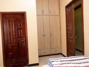 a bedroom with wooden cabinets and a bed in a room at Veb in Kampala