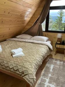 a bedroom with a bed in a log cabin at Brvnara Šapat Borova Tara in Sekulić 