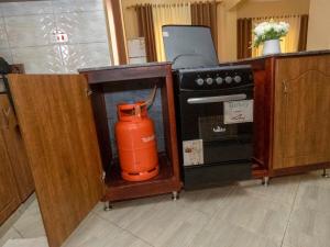 an orange blender in a kitchen next to an oven at Veb in Kampala