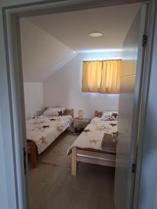 a bedroom with two beds and a window and a door at VIKENDICA GARAŠKI KUTAK in Arandelovac +27 photos