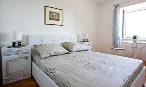 a white bedroom with a bed with a window at Apartment Banjo Polo in Split