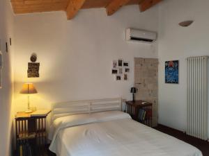 una camera con un letto bianco e due comodini di La Moka sul Camino a Brisighella