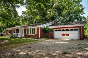 a red brick house with two white garage doors at Three Bedroom Cabin in Nashville
