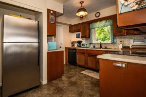 a kitchen with a stainless steel refrigerator and wooden cabinets at Three Bedroom Cabin in Nashville +14 photos