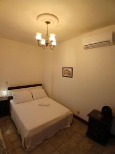 パルミラにあるApartamento Amplio y Cómodo en el centro de Palmiraの白いベッドとシャンデリアのある寝室