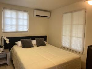 a bedroom with a large bed with two windows at Magic Castle Unit 7 in Santa Clarita +11 photos