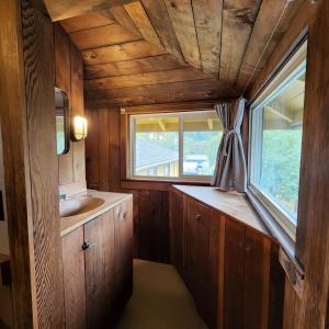 a small bathroom with a sink and a window at Unique Farm Apartment with Woodstove in Eureka