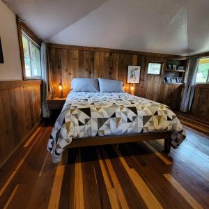 a bedroom with a bed in a room with wooden walls at Unique Farm Apartment with Woodstove in Eureka +9 photos