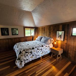 a bedroom with a bed in a room with wooden walls at Unique Farm Apartment with Woodstove in Eureka