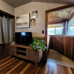a living room with a television on a wooden table at Unique Farm Apartment with Woodstove in Eureka