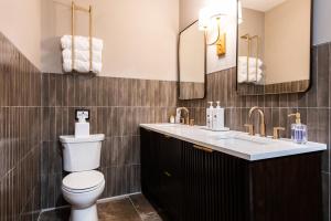 a bathroom with a toilet and a sink and mirrors at Hollyhock Suite 512 in Louisville