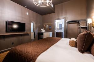 a bedroom with a large bed and a flat screen tv at Hollyhock Suite 512 in Louisville