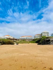 una playa de arena con edificios en el fondo en Studio avec balcon à 50 m de la corniche vendéenne, en Saint-Hilaire-de-Riez