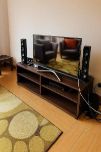 a living room with a flat screen tv and two chairs at cozy Apartment at Fenessi, Westlands Nairobi in Nairobi