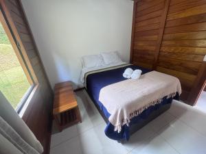 a small bedroom with a bed with towels on it at Sítio Martinelli, Caravaggio in Santa Teresa