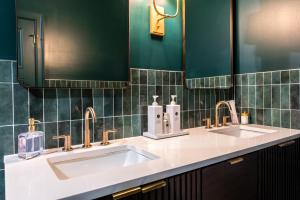 een badkamer met 2 wastafels en groene tegels bij Hollyhock Suite 511 in Louisville