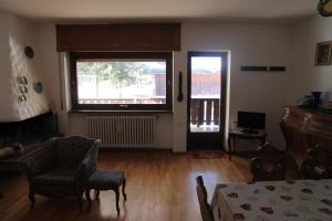 a living room with a table and chairs and a window at Appartamento in chalet ampezzano in Alvera