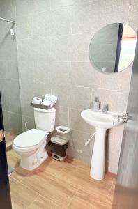 un bagno con un water, un lavandino e uno specchio di Casa Mirador de la Montaña - Campestre - Villa de Leiva - Moniquira a Santa Sofía