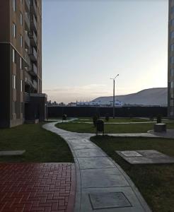 einen Gehweg in einem Park neben einem Gebäude in der Unterkunft Departamento 3 dormitorios Tacna en condomio privado in Tacna