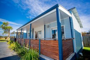 une maison bleue et blanche avec une clôture en bois dans l'établissement BIG4 Port Fairy Holiday Park, à Port Fairy