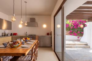 a kitchen with a long wooden table and a dining room at New! Villa Can Xic in Santa Eularia des Riu
