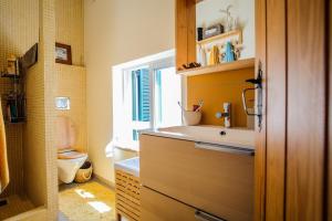 a bathroom with a sink and a toilet and a window at Casa do Mar - Familiar T3 Duplex - Terraço - Central in Nazaré +41 photos