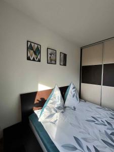 Un dormitorio con una cama con sábanas y almohadas blancas. en Apartament Enea, en Oleśnica