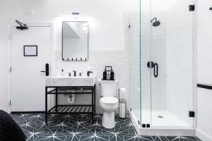 a bathroom with a toilet and a sink and a shower at Hollyhock Suite 509 in Louisville