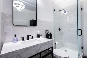 a bathroom with a sink and a toilet and a mirror at Hollyhock Suite 509 in Louisville