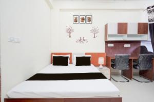 a bedroom with a large bed and a desk at Hotel O Radha Residency in Dahmi +45 photos