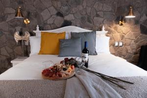 a bed with a plate of food and a bottle of wine at Luxury in Val'quirico in Santeagueda