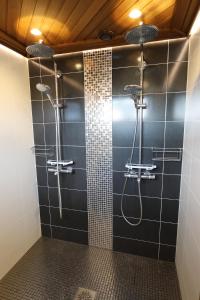 a bathroom with a shower with black tiles at Luxury Apartment in the Heart of Pello in Pello