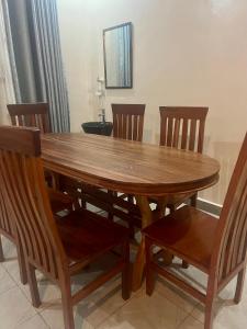 a wooden dining room table with chairs and a mirror at KIGALi GARDEN VILLA HOMES in Kigali