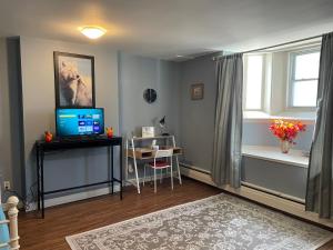 a room with a desk with a television and a window at Castle on Coburg in Rothesay