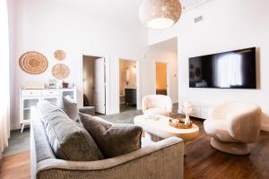 a living room with a couch and two chairs and a tv at Hollyhock Suite 507 in Louisville