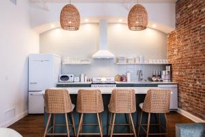 a kitchen with a counter and three stools at Hollyhock Suite 507 in Louisville