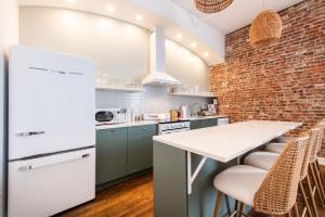 a kitchen with a brick wall and a white refrigerator at Hollyhock Suite 507 in Louisville +19 photos
