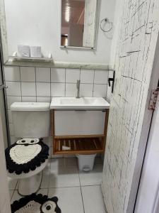 Un baño pequeño con lavabo e inodoro. en Estúdio casa condomínio Carasol, en Caraguatatuba