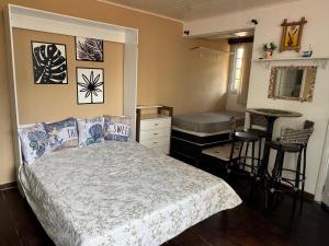 1 dormitorio con cama, mesa y bar en Estúdio casa condomínio Carasol, en Caraguatatuba 34 fotos más