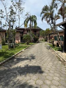 una calle vacía frente a una casa con palmeras en Estúdio casa condomínio Carasol, en Caraguatatuba