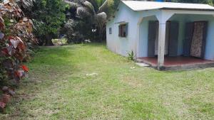 une petite maison bleue avec une pelouse dans l'établissement Petite Maison Sainte-Marie, Madagascar, sur l'île Sainte-Marie