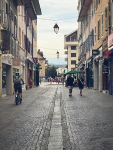 un gruppo di persone in bicicletta lungo una strada lastricata di ciottoli di Hotel Thonon Centre Le Comte Rouge a Thonon-les-Bains
