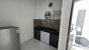 a small kitchen with a sink and a refrigerator at Air Rooms in Lohārakot +12 photos