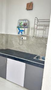 a kitchen with a counter with a sink and a counter at Air Rooms in Lohārakot