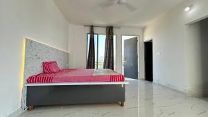 a bedroom with a bed with pink sheets and a window at Air Rooms in Lohārakot